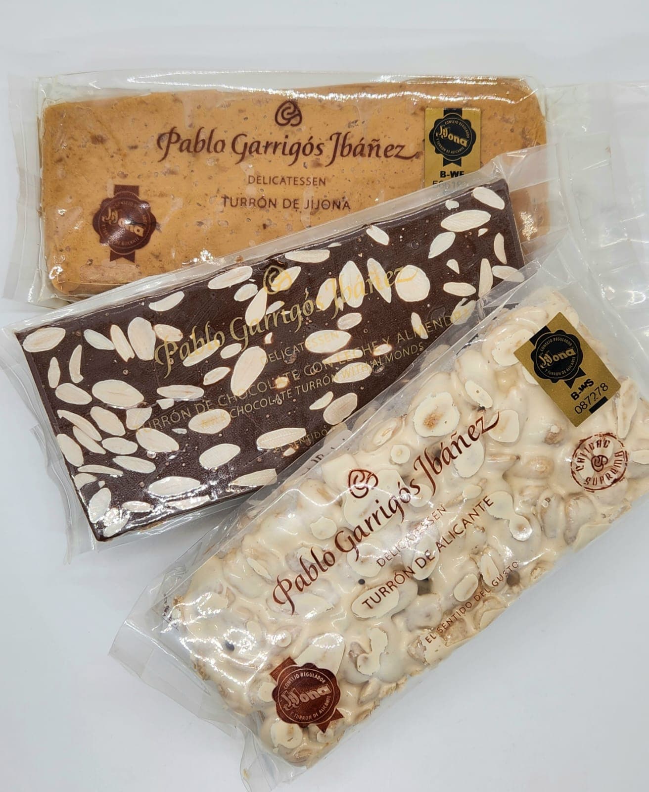 Three bars of Pablo Garrigós Ibáñez turrón: soft Jijona, chocolate almond, and hard Alicante.